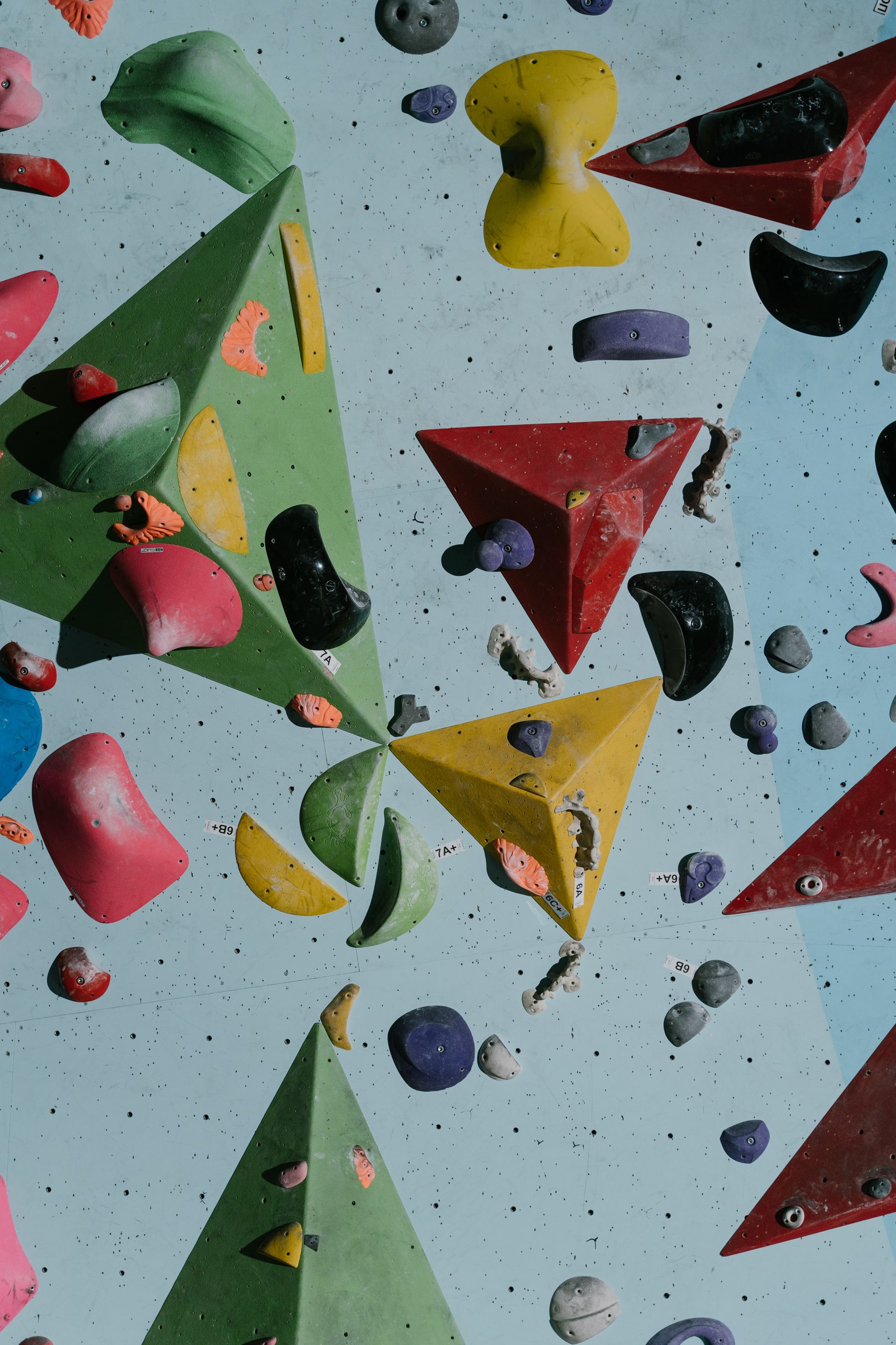 A colorful indoor bouldering wall with climbing holds
